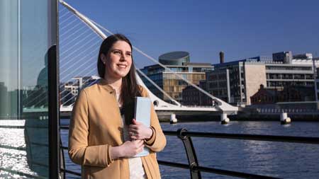 img_female_student_standing_beside_river.jpg